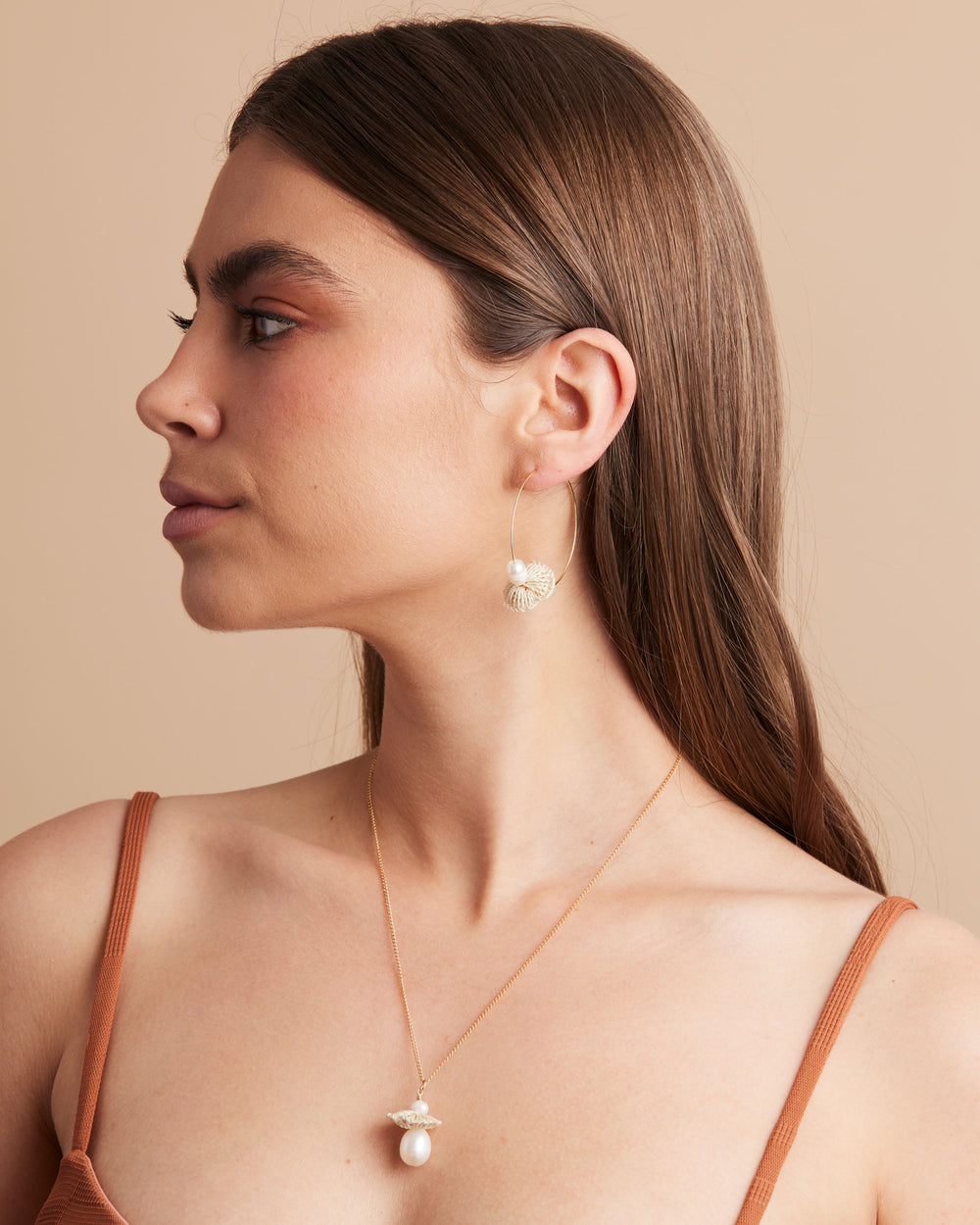 Model wearing gold filled necklace with natural fibre and pearl pendant