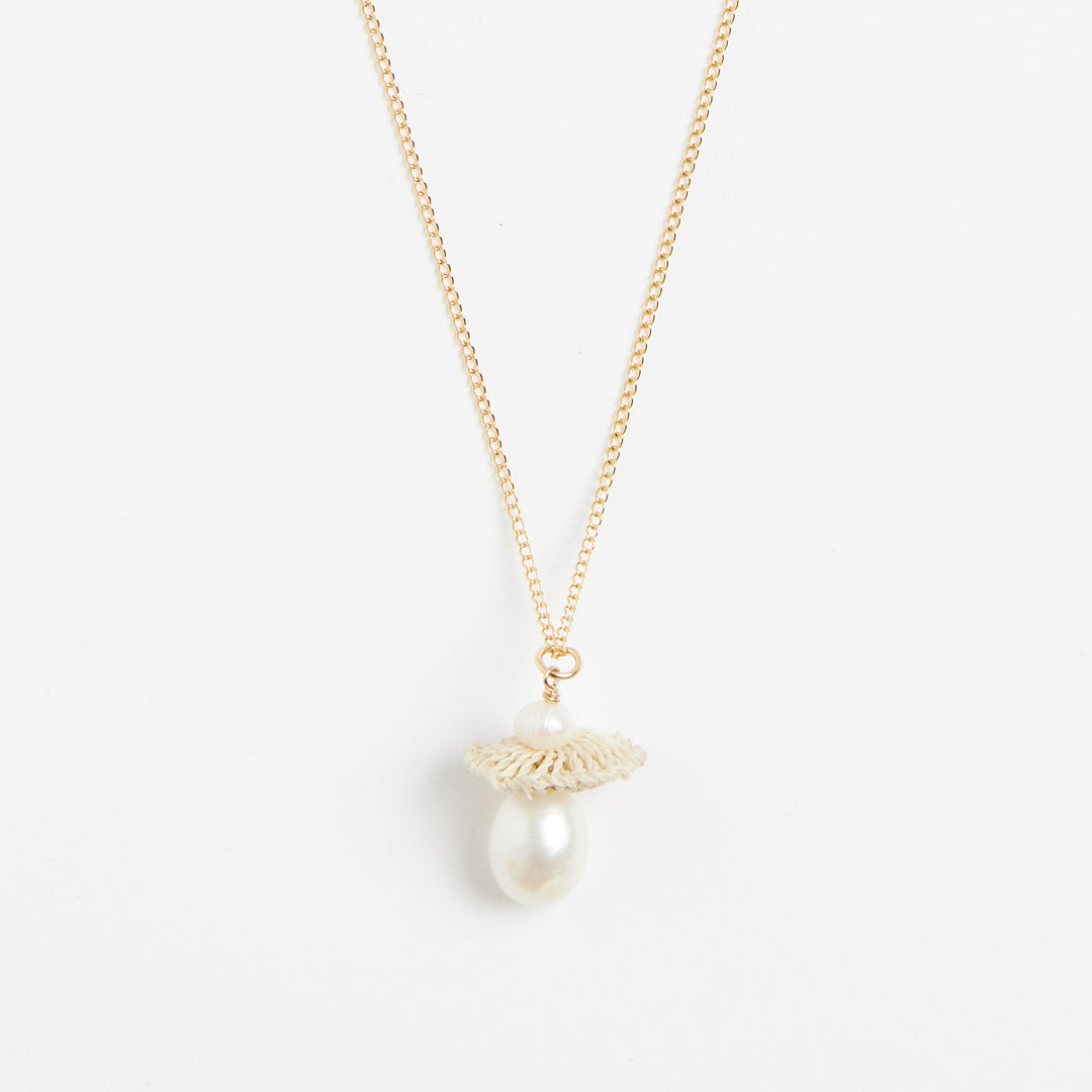 Close up of gold filled necklace with natural fibre and pearl pendant