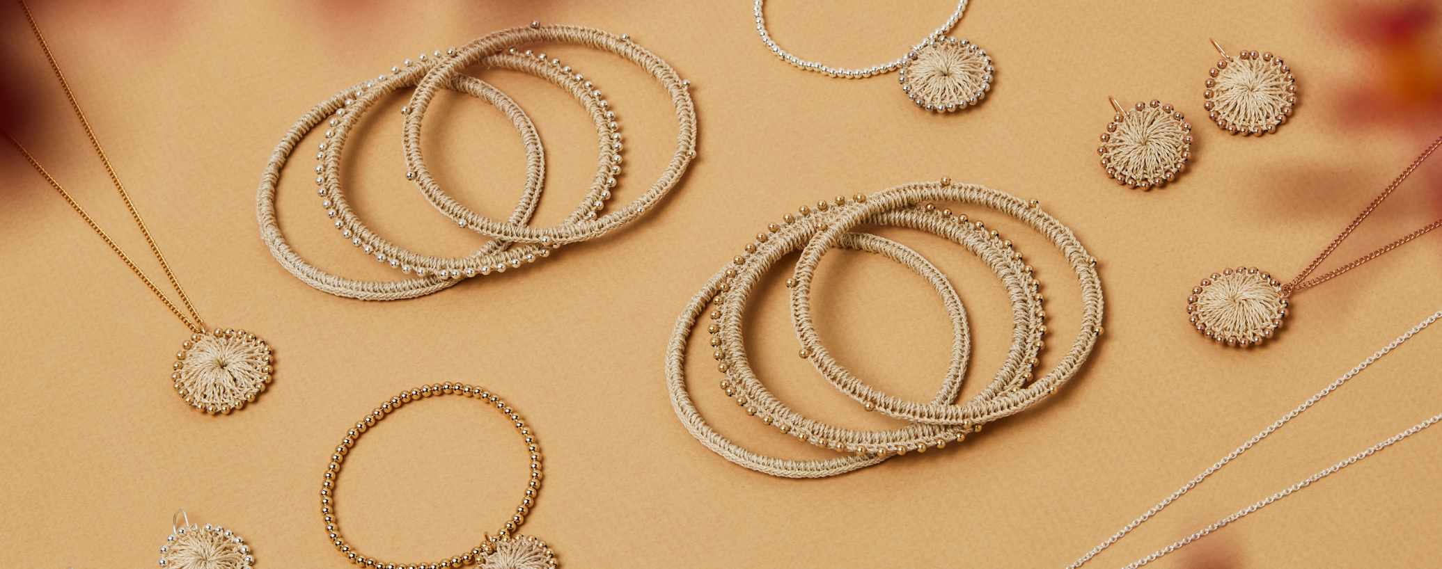 bilum and bilas jewellery collection flat lay on burnt orange background
