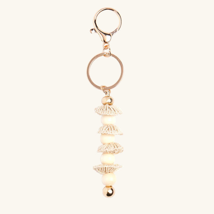 Gold keychain with decorative elements on a white background
