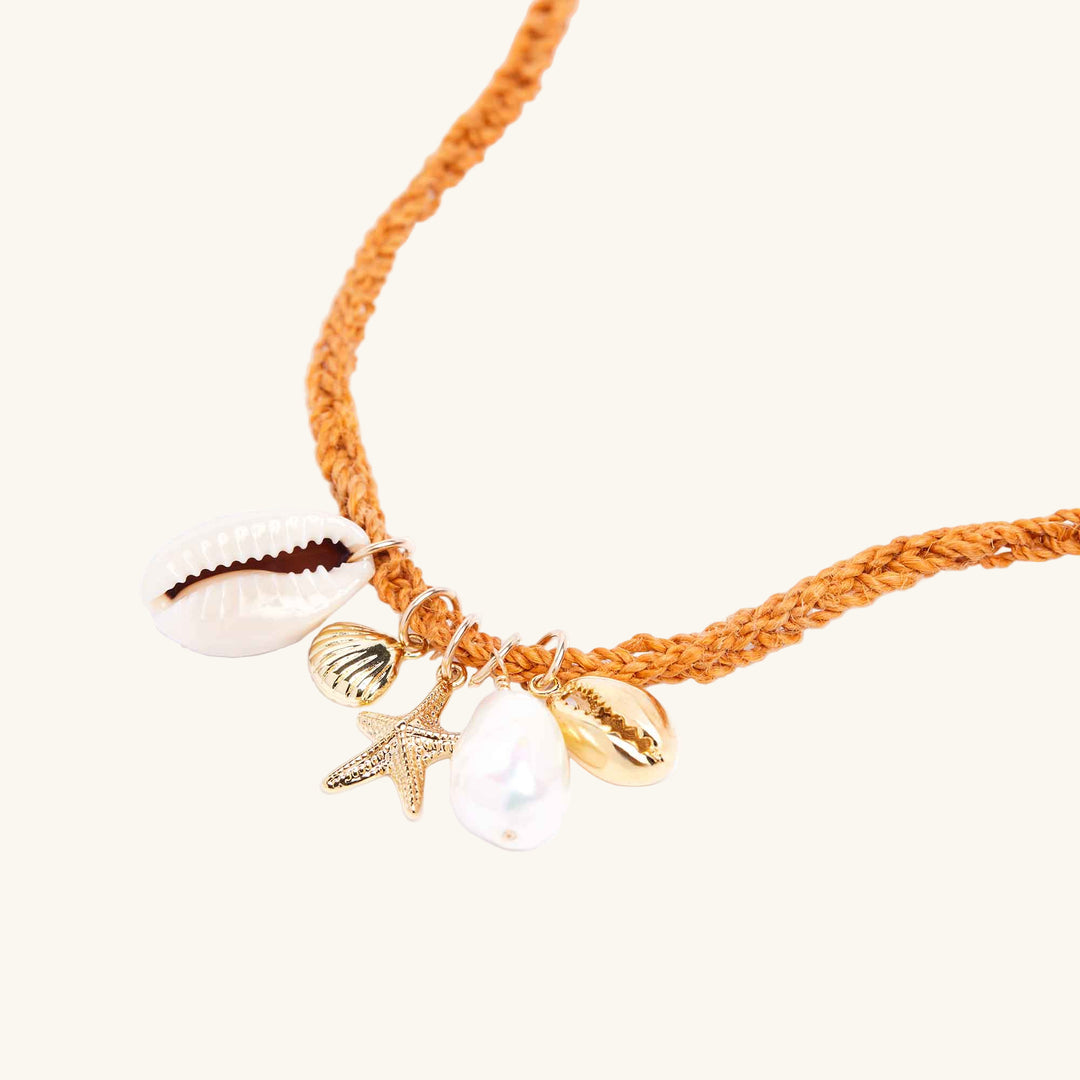 Bracelet with shell and starfish charms on a white background