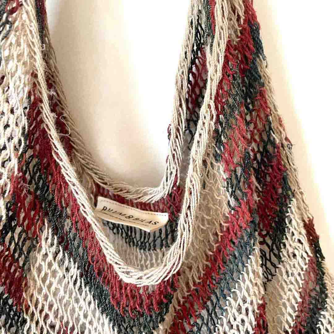 Opening of traditional brown and green tone string bilum bag from Moment Village in Papua New Guinea hanging.