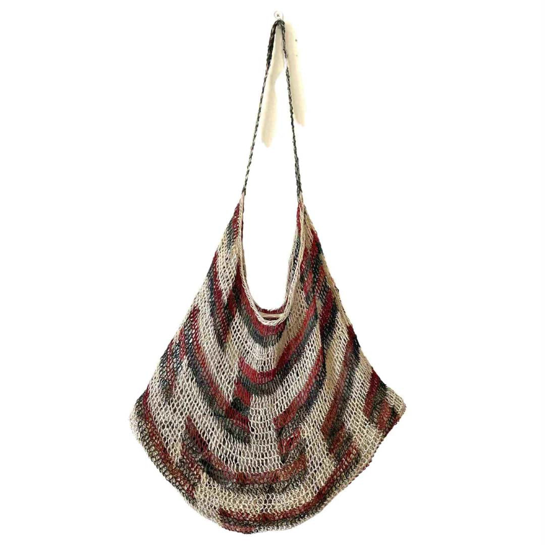 Traditional brown and green tone string bilum bag from Moment Village in Papua New Guinea hanging.