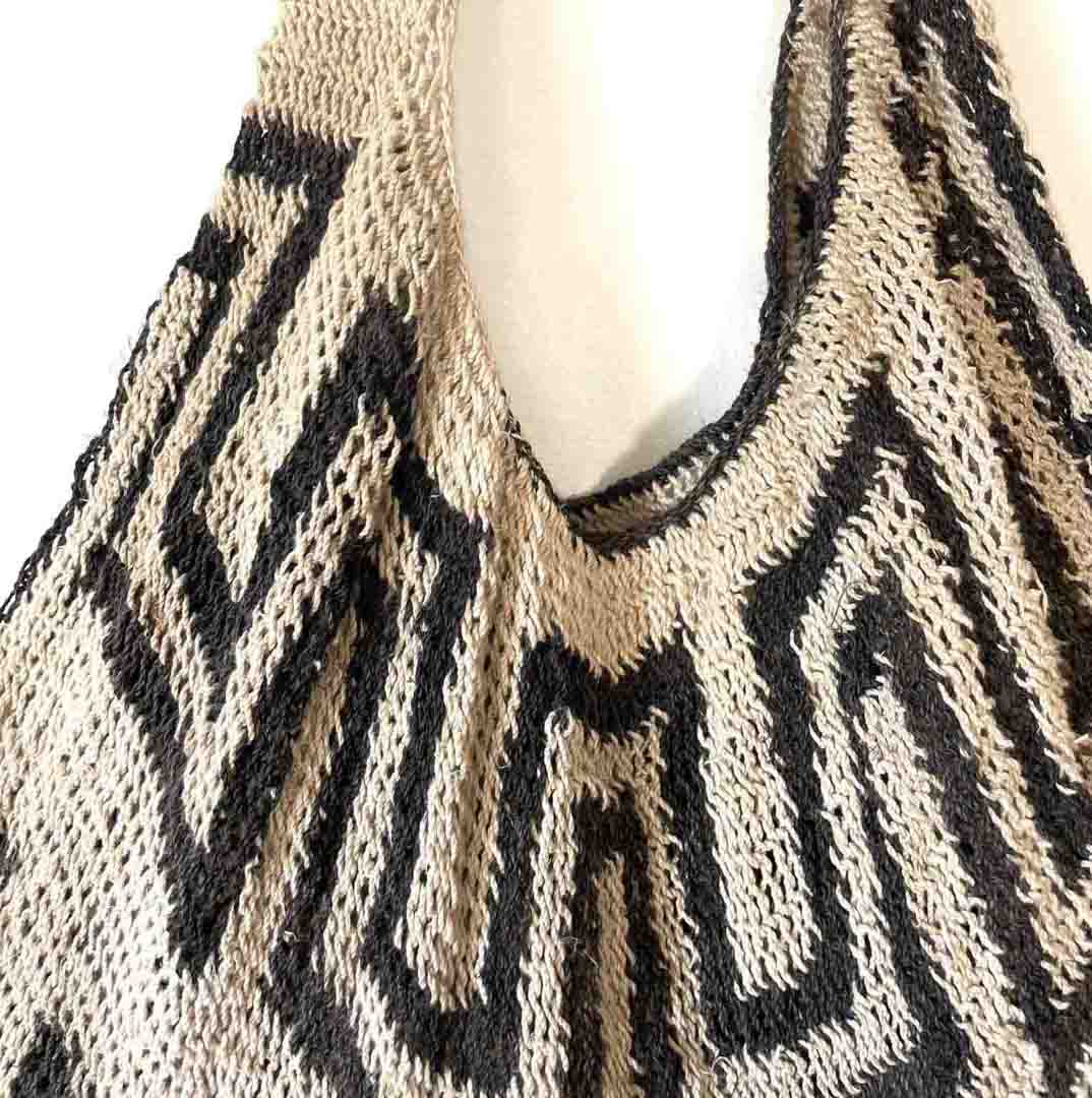 Close up on opening of black and white patterned natural fibre string bilum bag from Papua New Guinea.