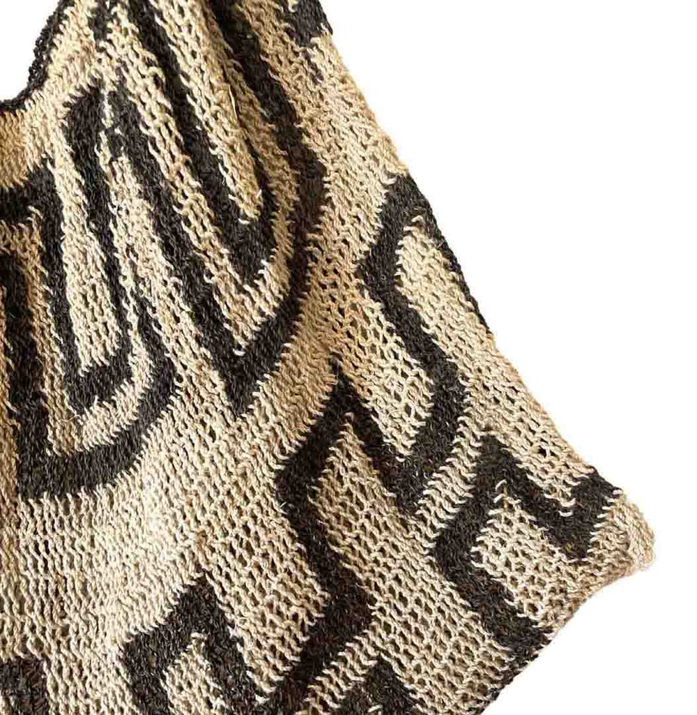 Corner close up on black and white patterned natural fibre string bilum bag from Papua New Guinea.