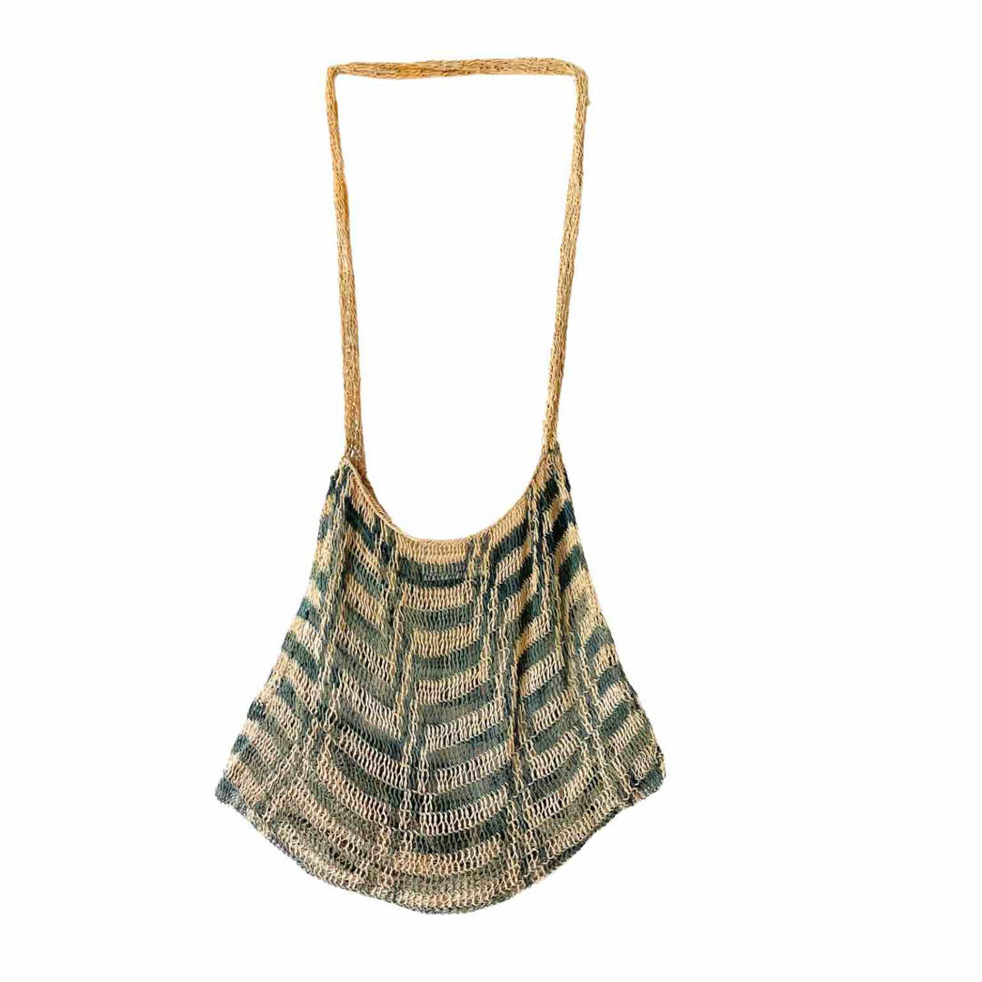 Green and white patterned natural fibre bilum hanging up.