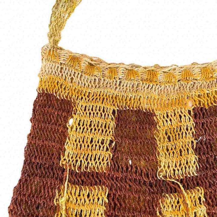Close up on opening of yellow and brown natural fibre bilum.