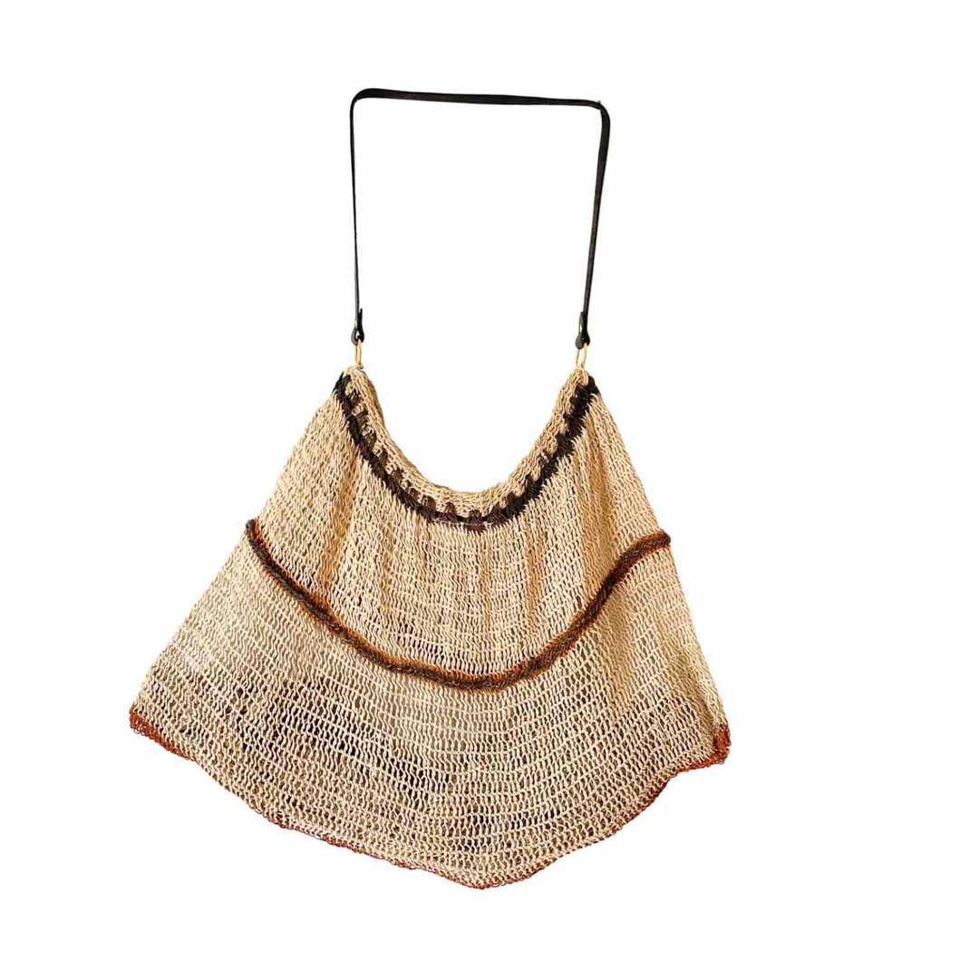 Striped natural fibre bilum with leather strap hanging on a white background.