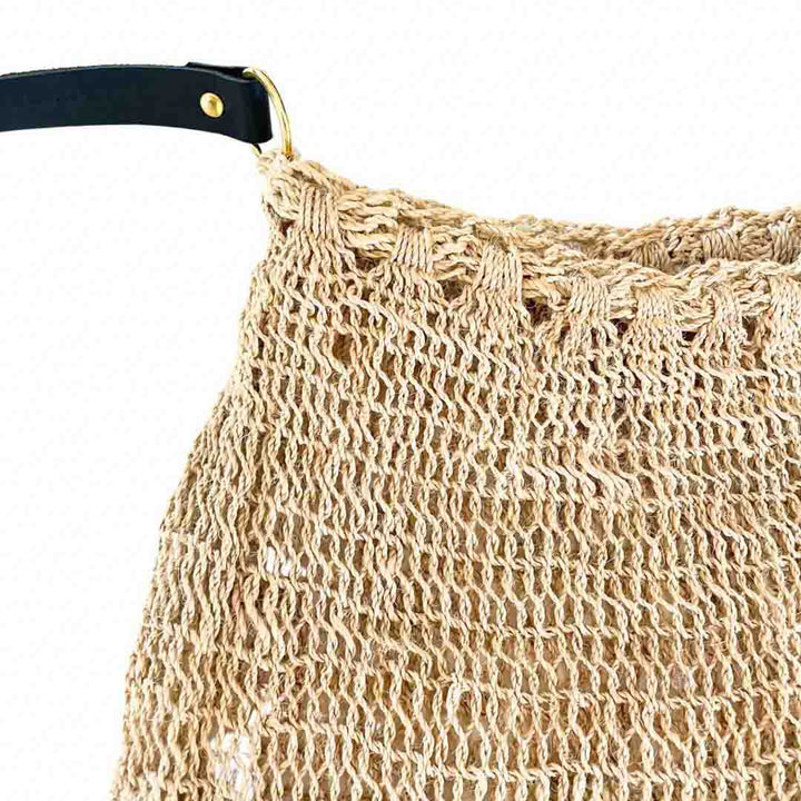 Close up on opening and strap of a natural fibre plain bilum with a leather strap.