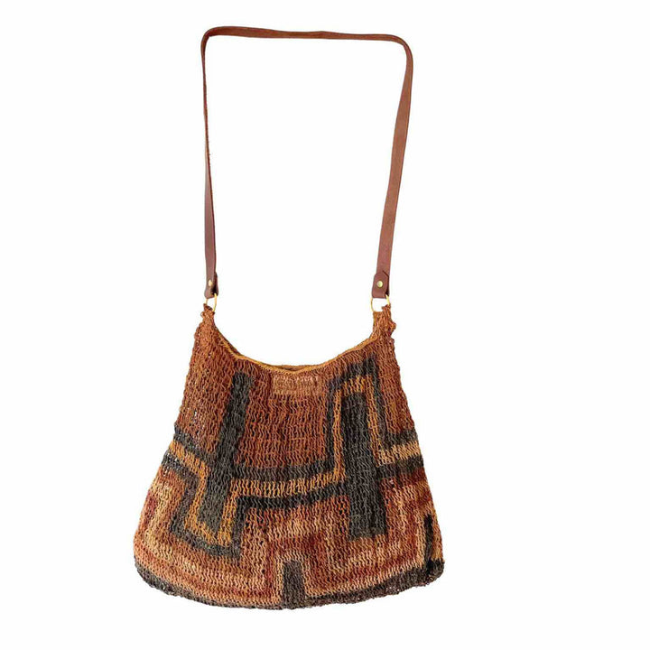Rich earth toned bilum with leather strap hanging on a white background.