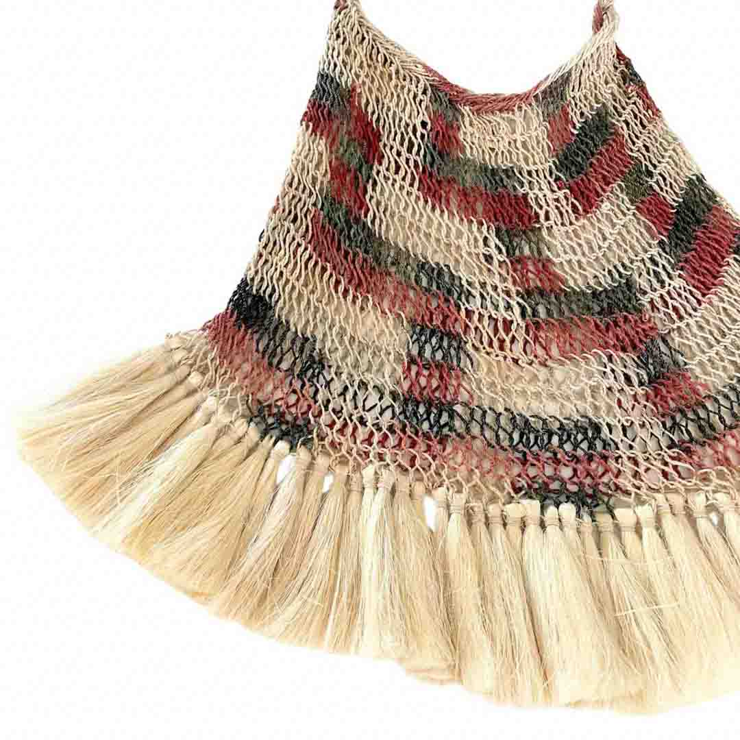 Corner detail shot of brown toned bilum with fringing.