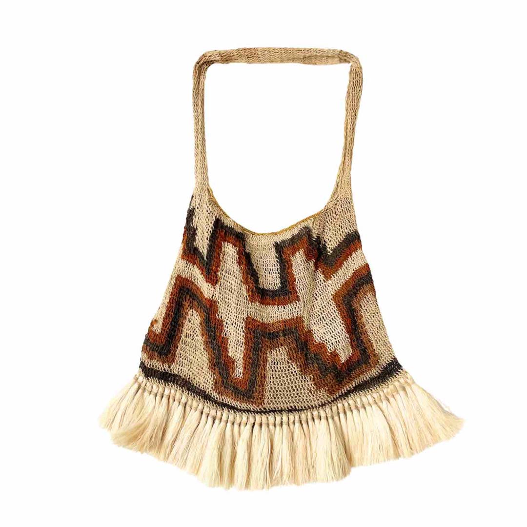 Traditionally patterned bilum with fringing hanging on display.
