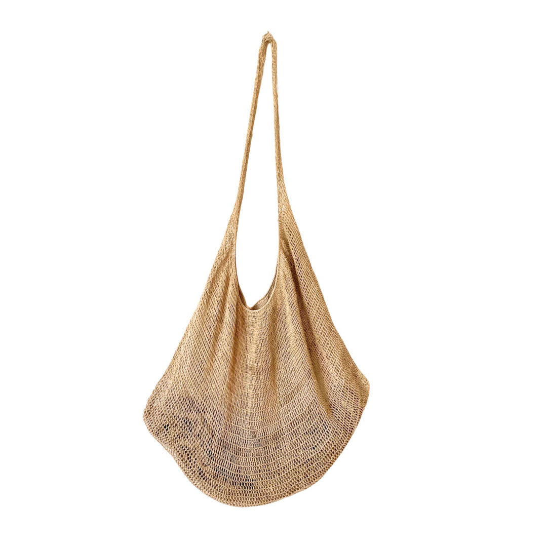 Plain natural fibre bilum hanging on a white wall.