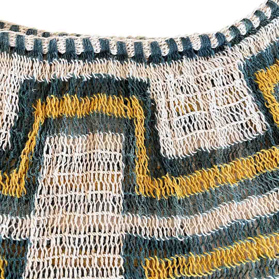 Opening of green and yellow patterned bilum.