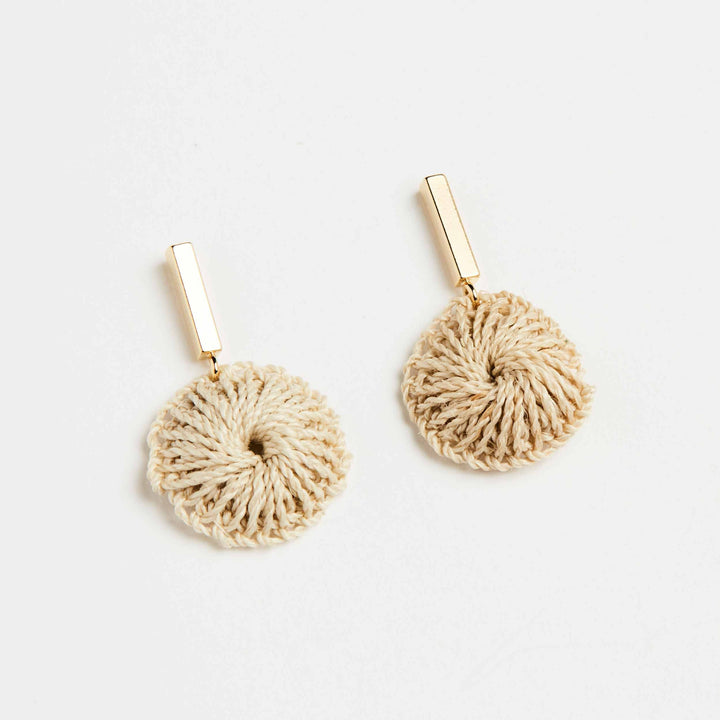 Bilum and Bilas gold bar earring with dangling handwoven natural fibre disc angled view