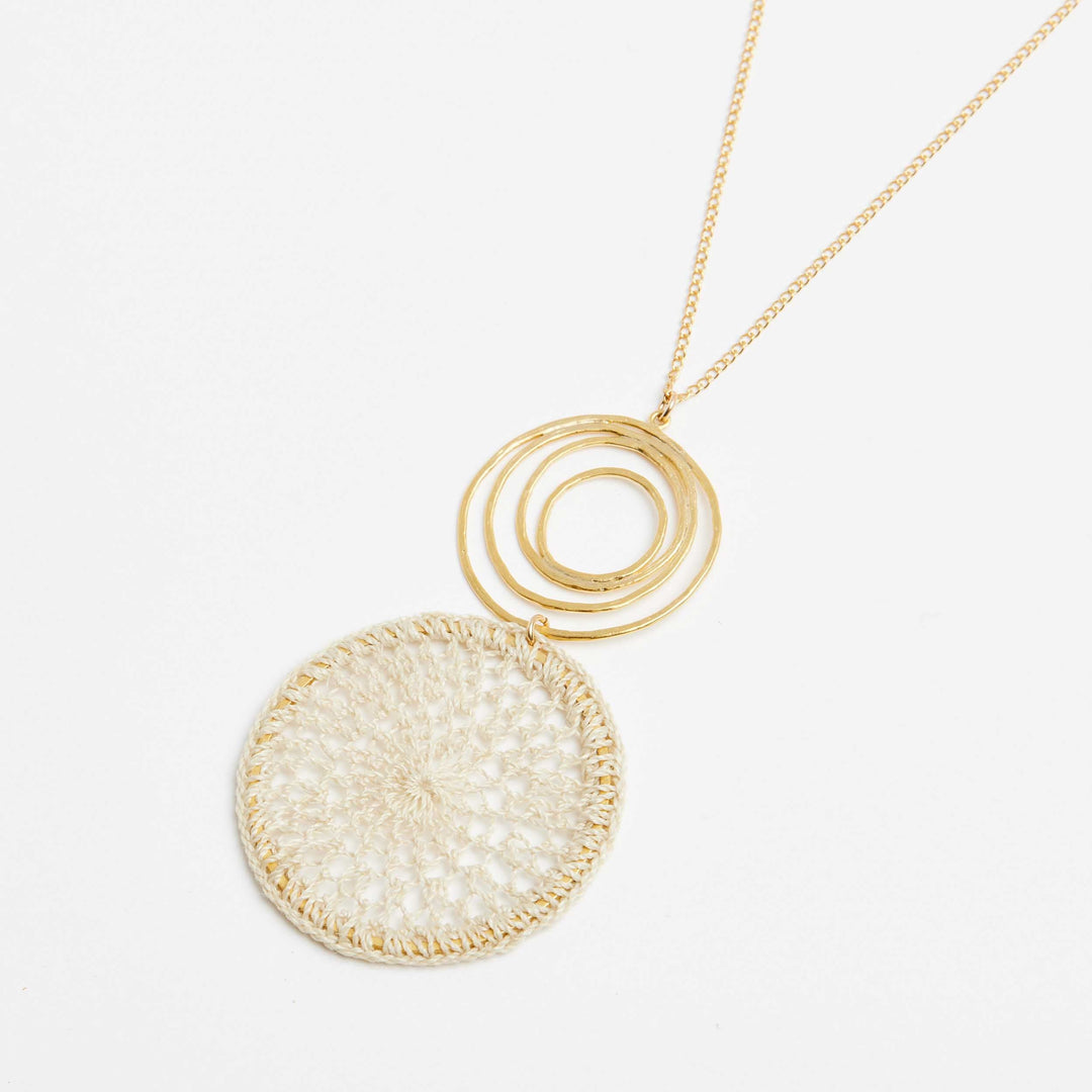 Gold filled fine chain necklace with gold swirl and natural fibre woven disc pendant side angle
