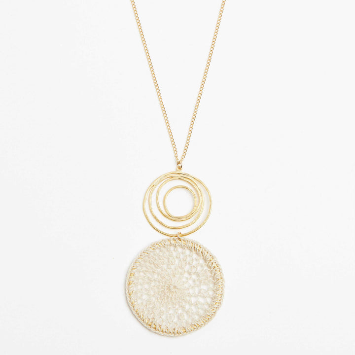 Gold filled fine chain necklace with gold swirl and natural fibre woven disc pendant close view