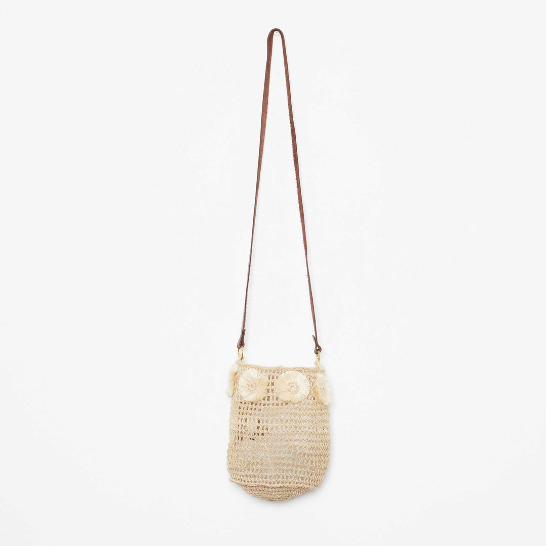 Handwoven cross body bag with natural fibre flower adornments on a white background