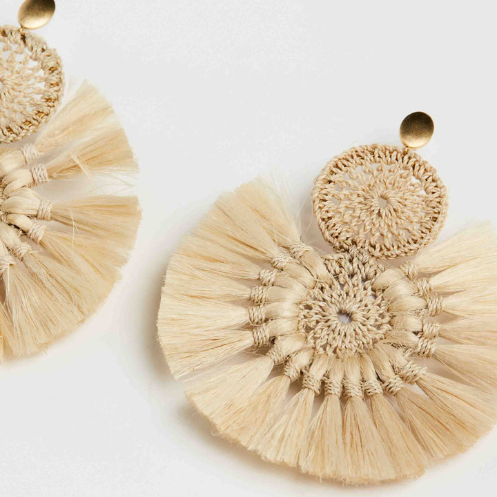 Bilum and Bilas Sandei statement earring detail view. Earring with double woven disc with natural fibre tassels.
