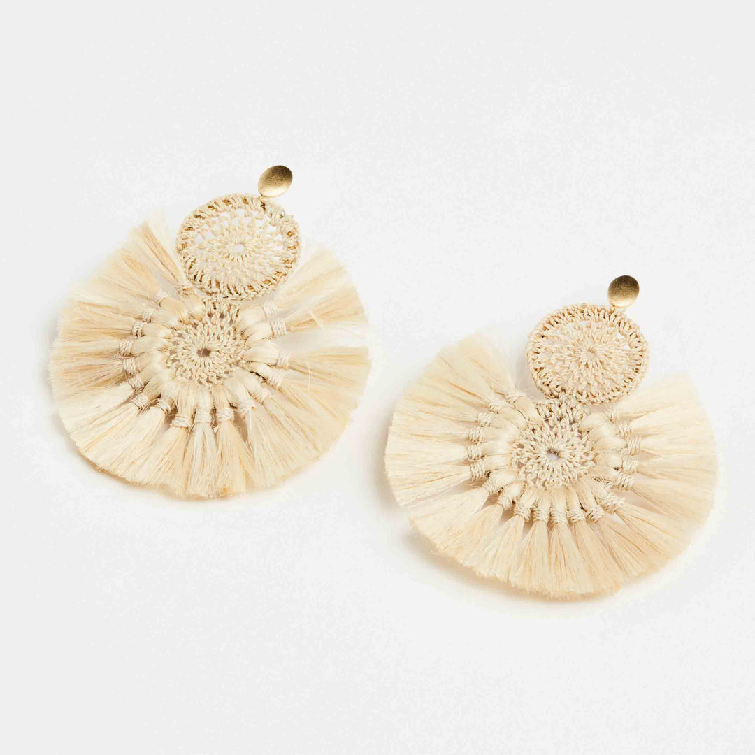 Bilum and Bilas Sandei statement earring angled view. Earring with double woven disc with natural fibre tassels.