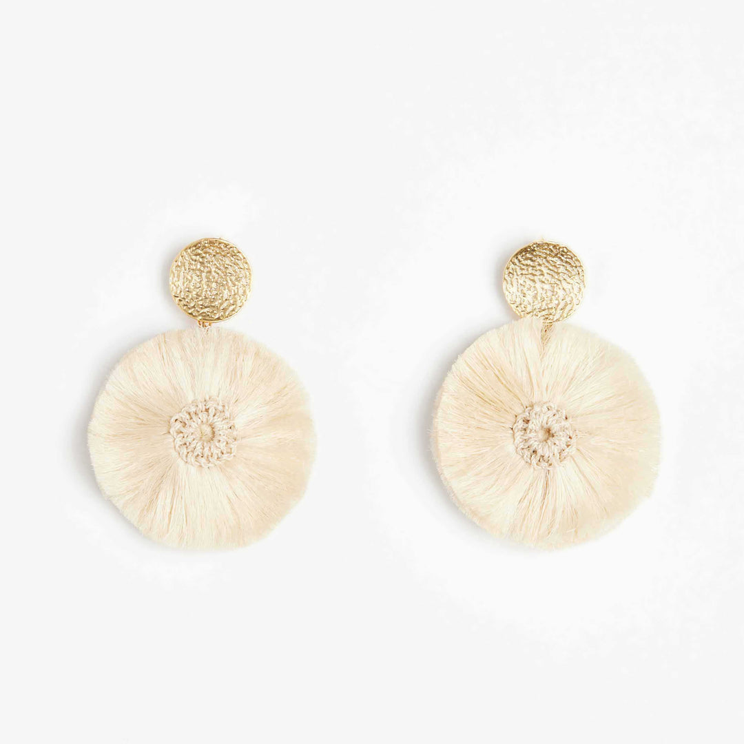 Natural Fibre and gold disc pom pom earrings on white background.