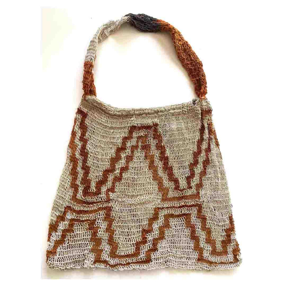Flat lay picture of orange and white string bilum from East Sepik Province displayed on a white background.