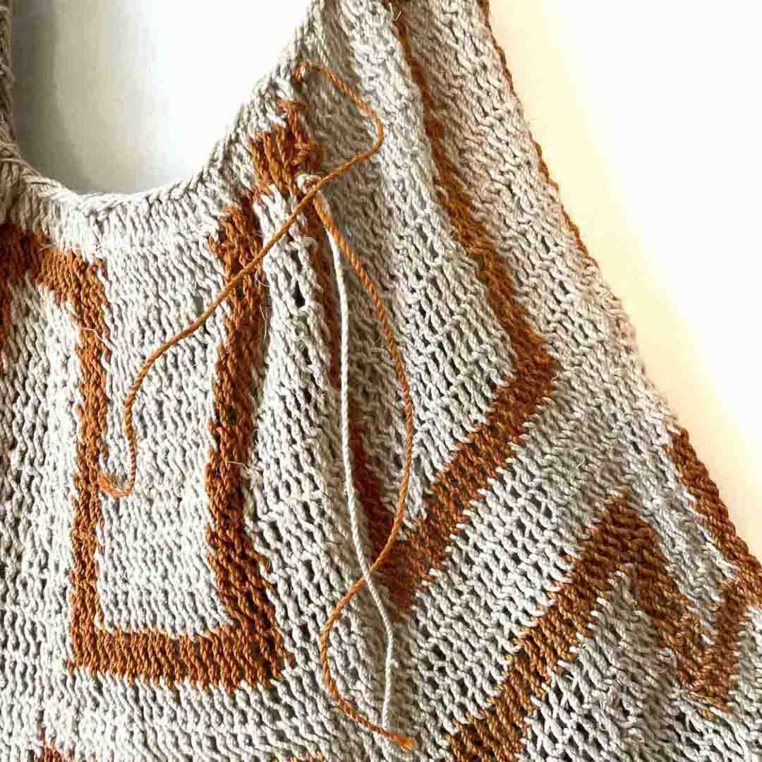 Close up on the weave in an orange and white string bilum from PNG.