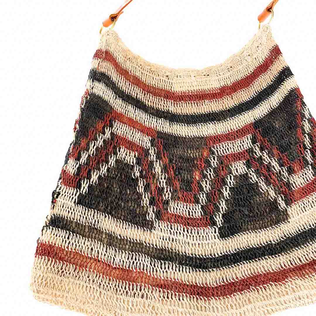 Close up on a brown patterned bilum with leather strap.