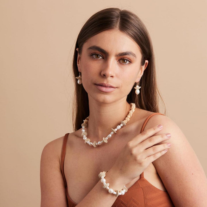Model posing in pearl stack necklace with matching bracelet and earrings