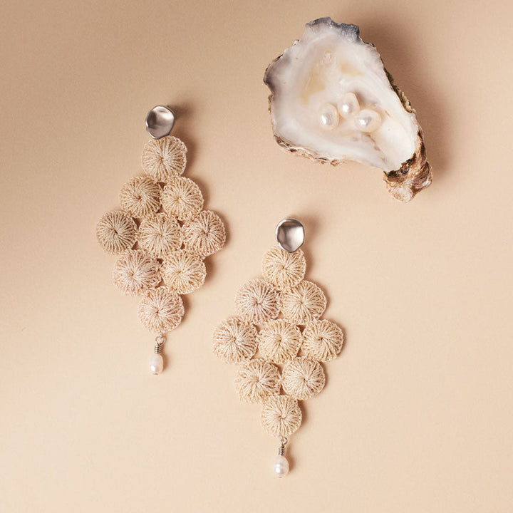 Silver and pearl with woven natural fibre statement Malalo Chandelier earrings still life with oyster shell