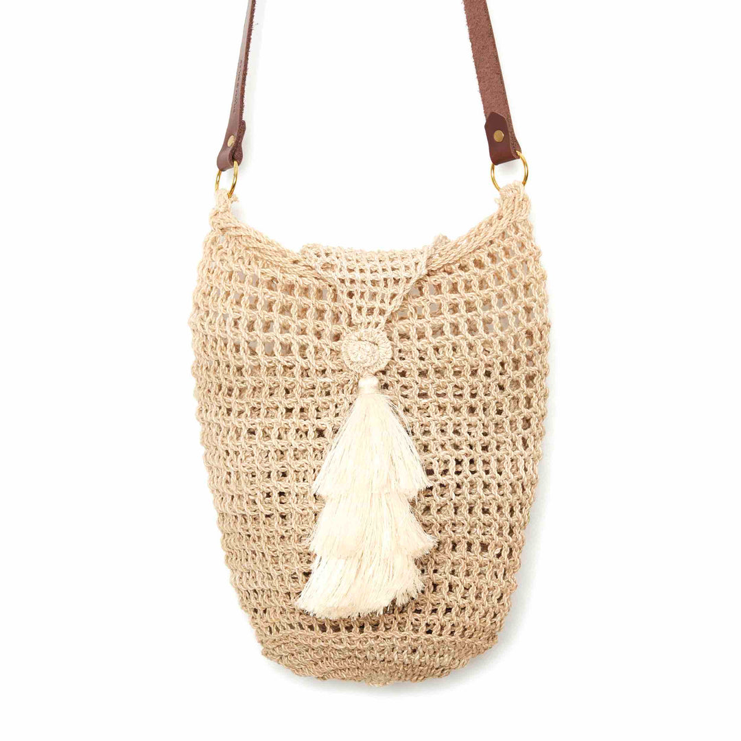 Close up of natural fibre bucket bilum with lid close and tassel hanging on a white background.