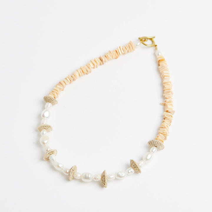 Side angle of the pearl stack necklace with pearls and natural fibre woven discs