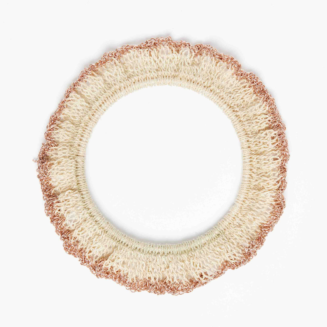 Natural fibre and rose gold metallic ruffle bracelet on white background.