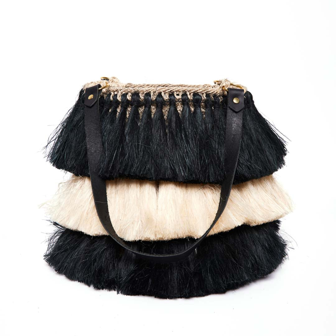 Black and white handwoven tassel bag on a white background.