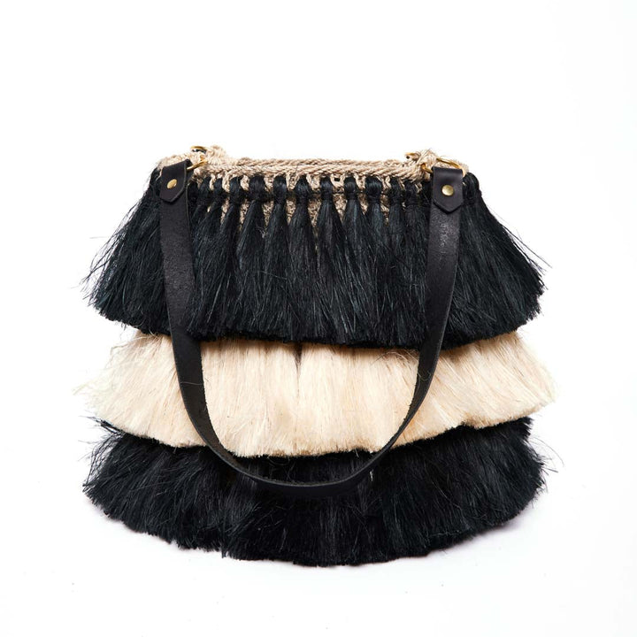 Black and white handwoven tassel bag on a white background.