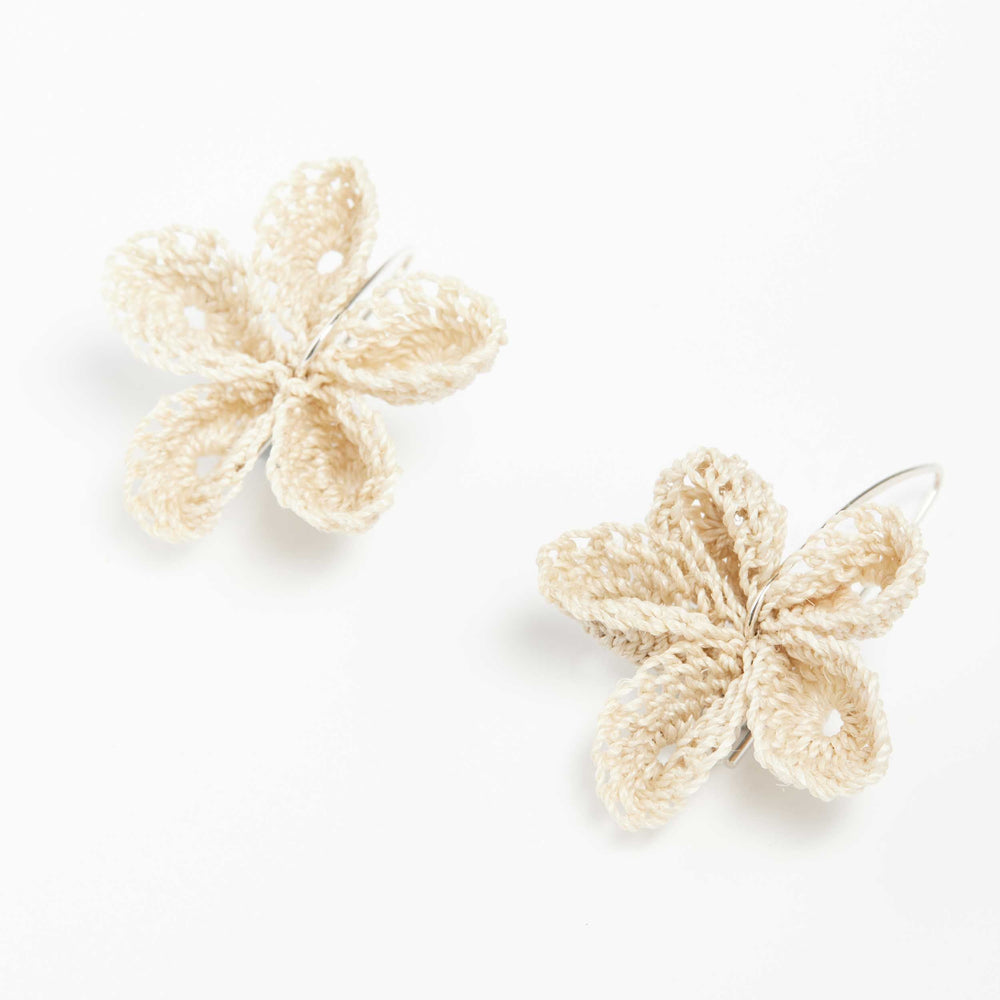 Silver and natural woven flower earrings close up. bilum and bilas