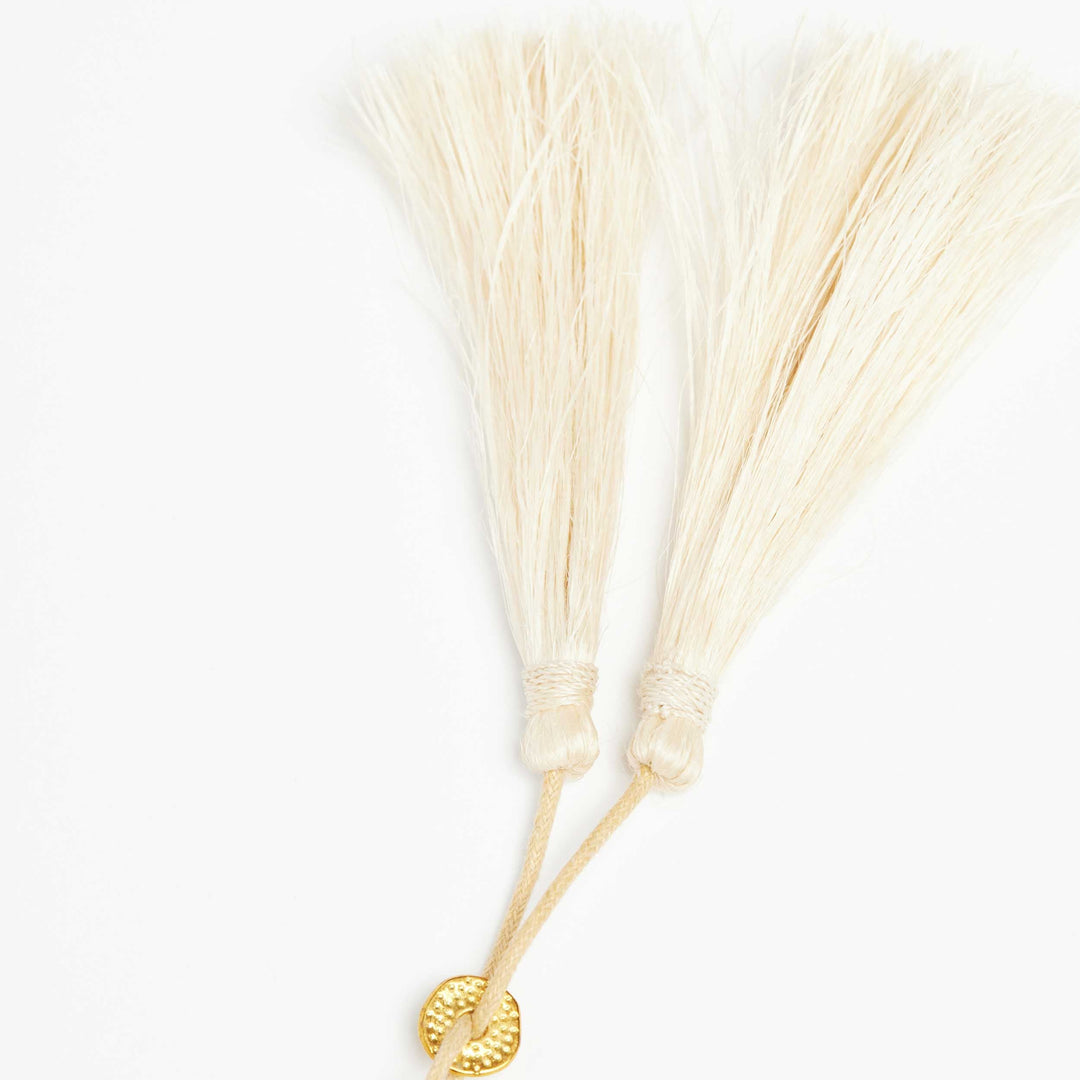 Detail of the adjustable slider on the statement woven hibiscus necklace.