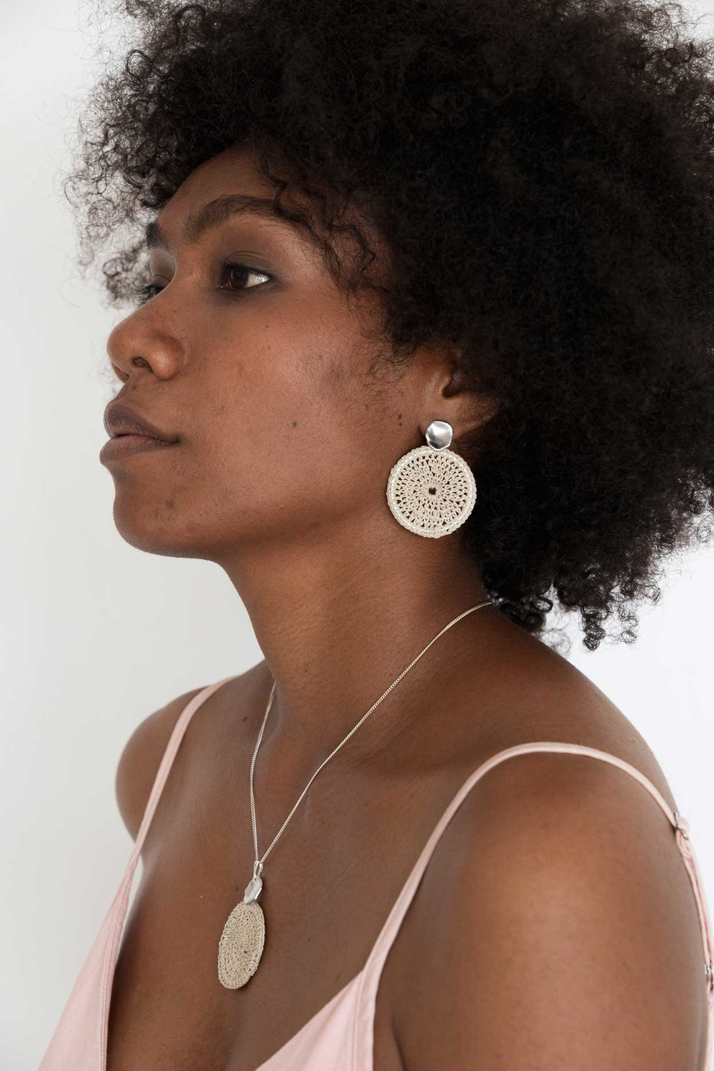 Model wearing Bilum and Bilas sowana disc earrings - Crochet woven disc earrings with silver ear post