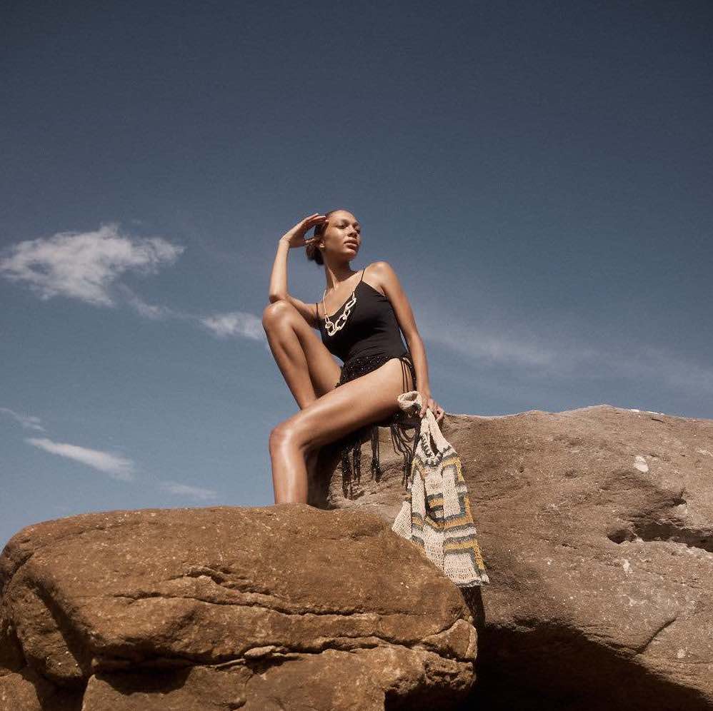 Model on rock wearing woven chain necklace.