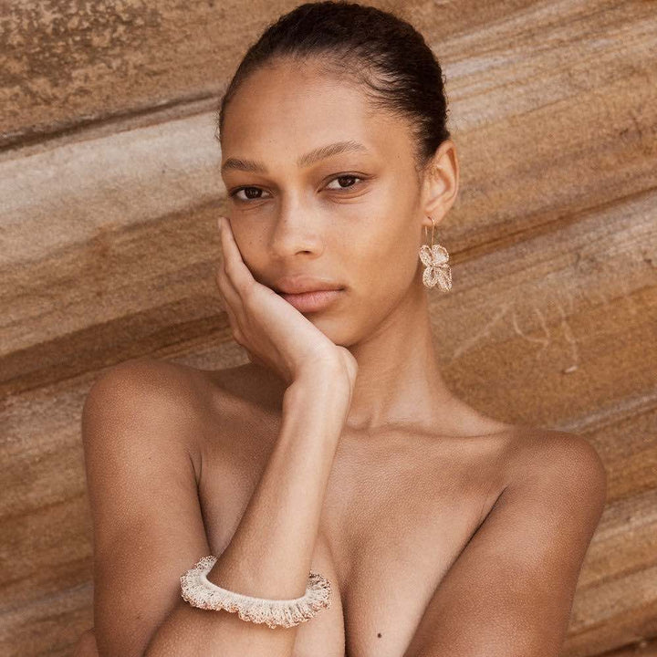 Natural fibre and rose gold metallic ruffle bracelet on model posing.