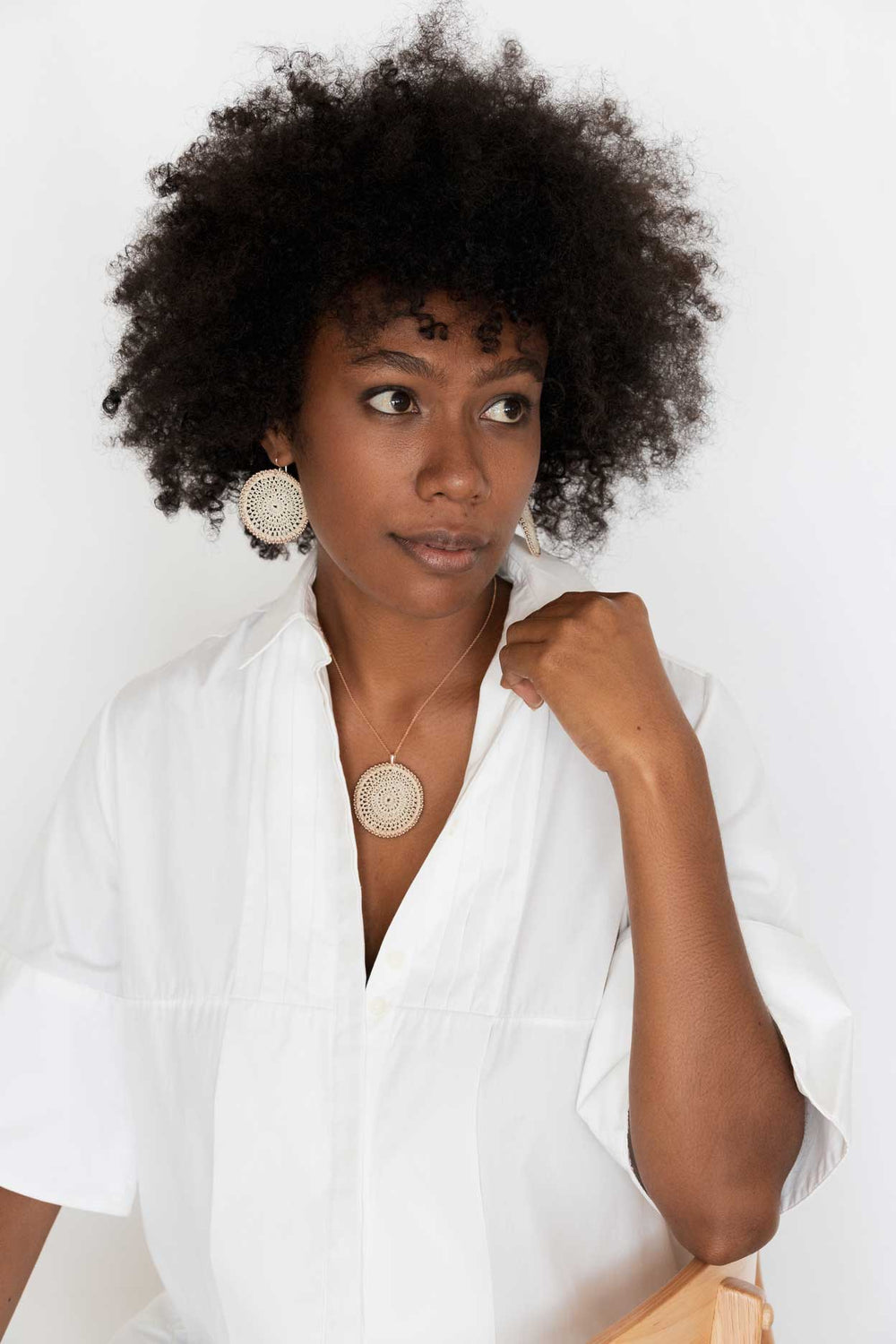 Model wearing the Bilum and Bilas Sunset earrings. Rose gold beaded natural fibre discs.