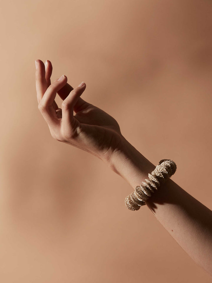 Bilum and Bilas Lewa stretch textile bead bracelet with a rose gold bead worn on models arm in a still life portrait