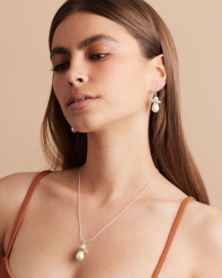 Model wearing bilum and bilas pearl drop neklace with a natural fibre and pearl pendant