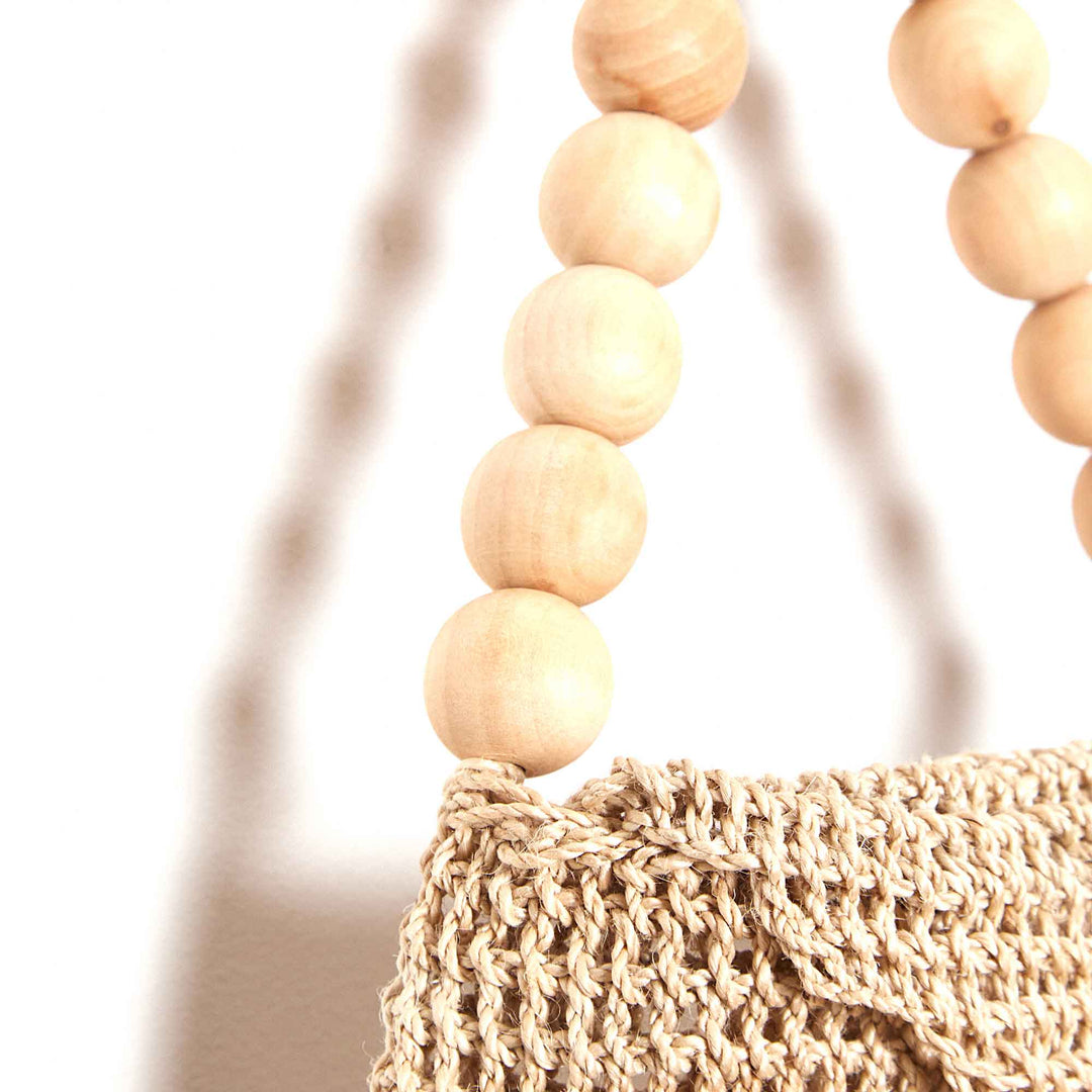 Beaded handle on woven bag