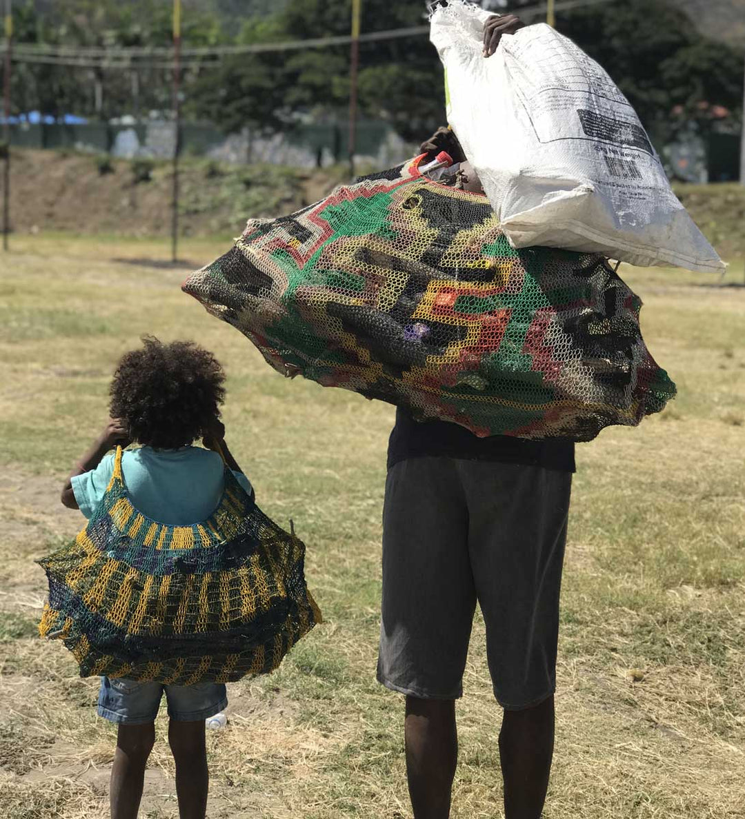 Mother and daughter carrying firewood in bilums on their heads