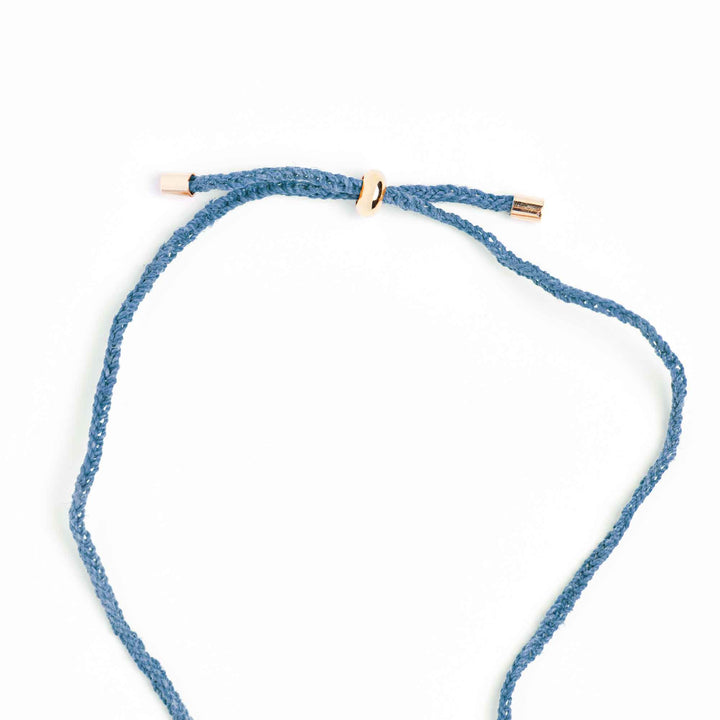 Blue braided necklace with gold clasp on a white background