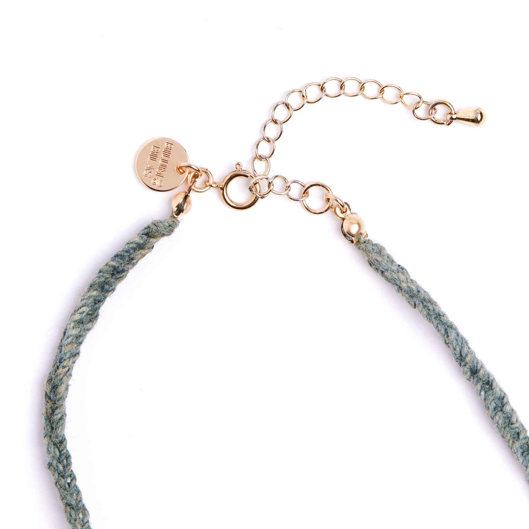 Necklace with green cord and gold clasp on a white background