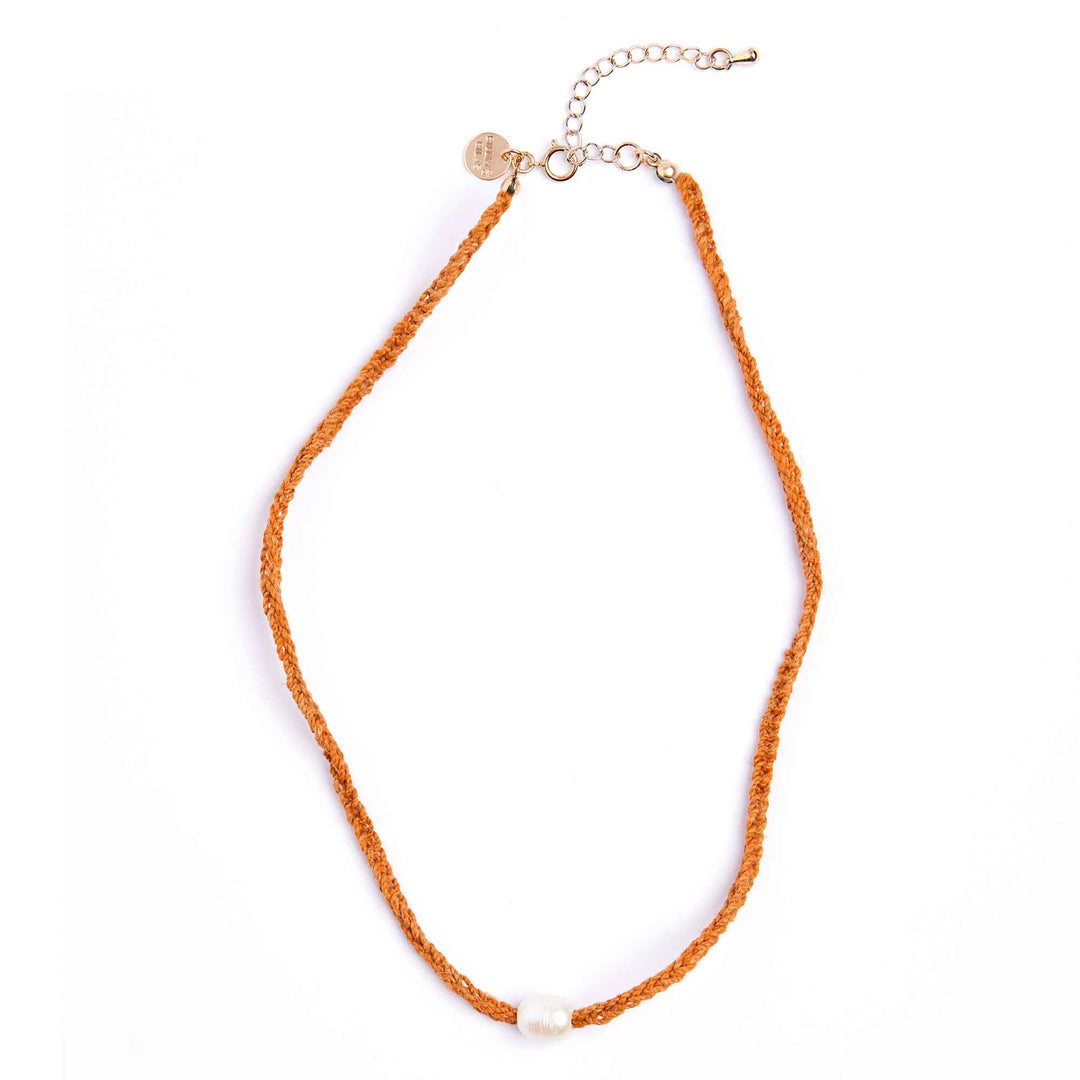 Orange necklace with a small heart charm on a white background