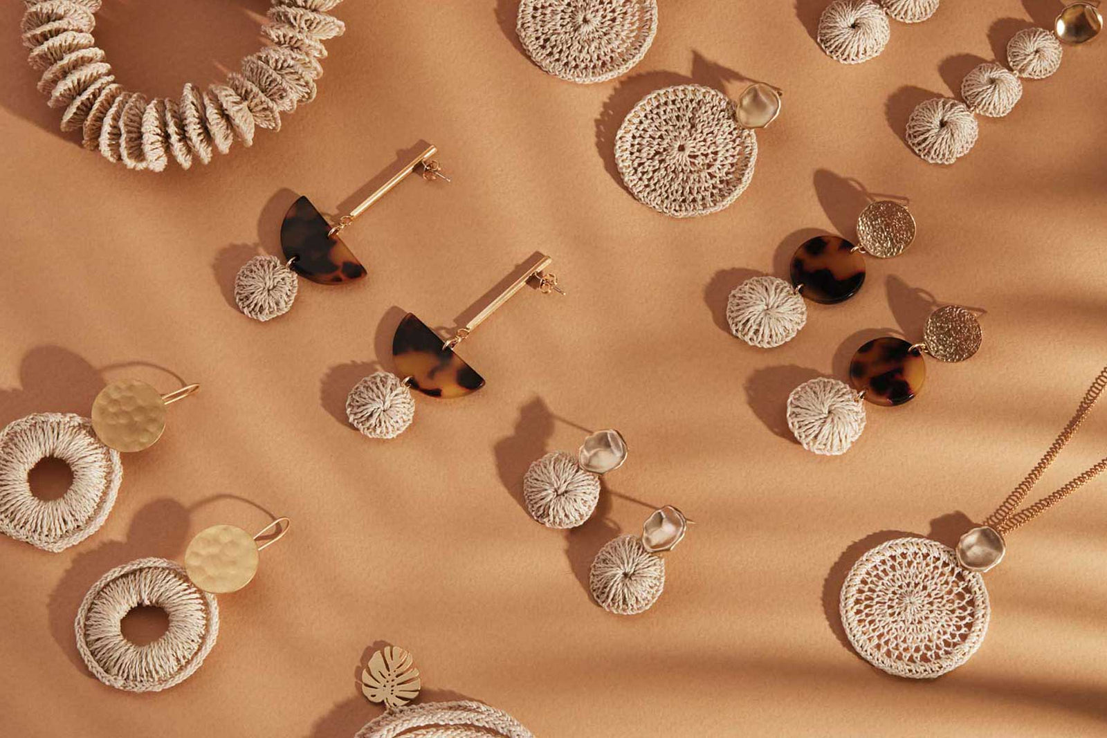 Bilum and Bilas Signature collection flat lay of jewellery on a rust background