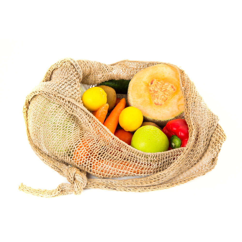 still life of a natural fibre bilum with knot handle with fruits inside